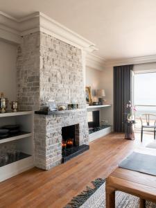 - un salon avec une cheminée en pierre et une table dans l'établissement Endless Sea View, à Knokke-Heist