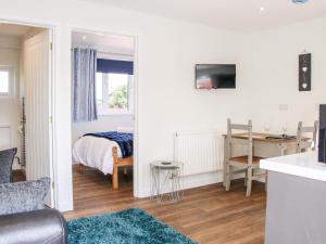 a bedroom with a bed and a desk with a television at Oakleigh in Llanymynech
