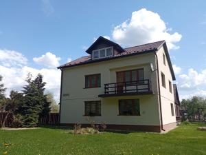 a white house with a balcony in a yard at Gospodarstwo Agroturystyczne U Zdzicha in Bałtów