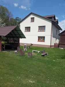 a large white house with a yard with a building at Gospodarstwo Agroturystyczne U Zdzicha in Bałtów