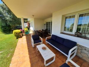 un patio con sofá, sillas y mesa en Villa Max, en Lloret de Mar