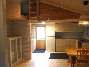 a kitchen with a table and a dining room at Pinetree Cottages Sunny cabin in Pyhäranta
