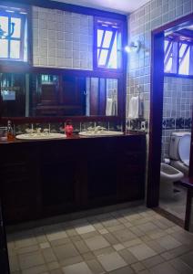 a bathroom with two sinks and a toilet at Numa Boa HOSTEL Búzios in Búzios