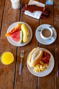 a table with plates of breakfast food and a cup of coffee at Pousada Nossa Senhora D'Ajuda in Arraial d'Ajuda +9 photos