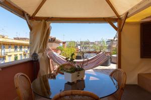 a hammock on a balcony with a table and chairs at Penthouse with Jacuzzi on Private Terrace in Trastevere in Rome