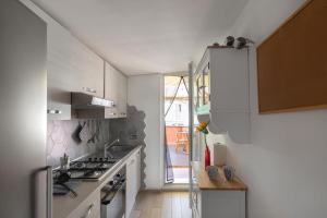 a white kitchen with a stove top oven next to a door at Penthouse with Jacuzzi on Private Terrace in Trastevere in Rome
