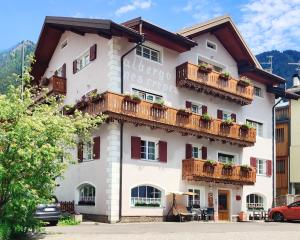 a large white building with balconies on it at Hotel Nès Crépes in Pozza di Fassa