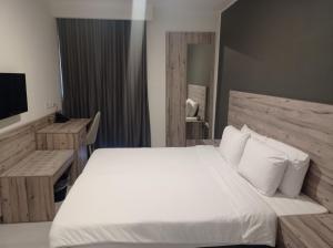 a bedroom with a large white bed and a television at Hotel VIU57 in Mellieħa