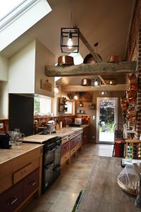 une grande cuisine avec des placards en bois et une cuisinière dans l'établissement Le Domaine des Agapanthes - SPA, à Épreville