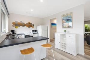 a kitchen with white cabinets and a black counter top at Sorrento Lifestyle Awaits in Sorrento +7 photos
