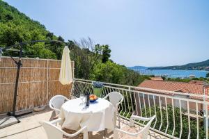 een tafel en stoelen op het balkon van een huis bij Apartments Villa Cerjak in Slano