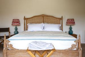 a bedroom with a wooden bed with two lamps at The Old Hop Kiln Barn in Petersfield