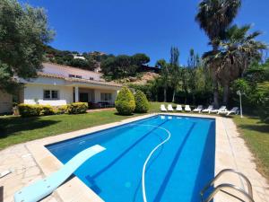 a swimming pool in front of a house at Villa Max in Lloret de Mar