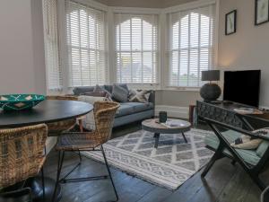 una sala de estar con un sofá y una mesa en 7 Belgrave Apartments, en Ilfracombe