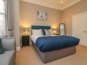 Un dormitorio con una cama, un sofá y un espejo. en 7 Belgrave Apartments, en Ilfracombe