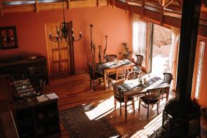 ein Esszimmer mit Tischen und Stühlen und einem großen Fenster in der Unterkunft Ti Melen Boutique Guesthouse in Windhoek