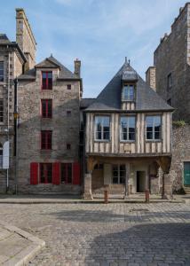 un antiguo edificio en un castillo con puertas rojas en La Maison Pavie en Dinan