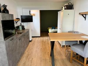 a kitchen with a table and a desk with a television at B&B de Danser in Klaaswaal