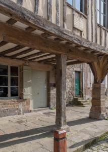a building with a wooden porch with a door at La Maison Pavie in Dinan