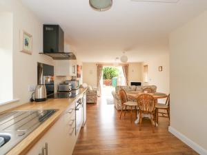 a kitchen and living room with a table and chairs at The Old Gate House Annexe in Alford