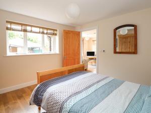 a bedroom with a bed and a window and a mirror at The Old Gate House Annexe in Alford