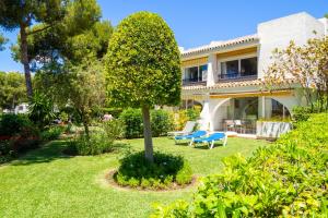 una casa con un banco azul en el patio en Miraflores, beach apartment, apartamento en la playa !, en Mijas Costa