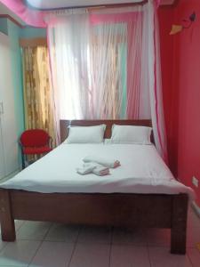 a bed with a canopy with two towels on it at Tommy's Lounge Apartments in Nairobi