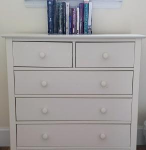 a white dresser in a bedroom with books at Solheimir at Strathmore Golf Course in Blairgowrie