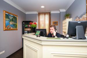 a man sitting at a desk talking on a cell phone at Albergo Locanda Primavera in Rodengo Saiano