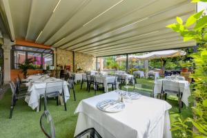 a restaurant with tables and chairs with white tablecloths at Albergo Locanda Primavera in Rodengo Saiano