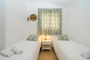 two twin beds in a small room with a table at Apartament Altea Spaniahome in Altea +17 photos