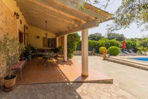 ブゲルにあるSa Sini Cozy country villa for 6 near Bugerの屋外パティオ(テーブル、椅子付)、プールが備わります。