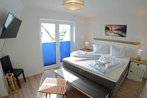a bedroom with a bed and a table and a television at Ferienhaus "Bootsmann" in Breege