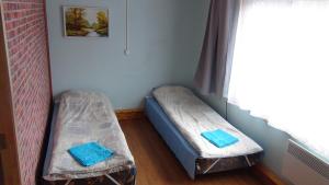 two beds in a room with a window at Livonia Matkamaja in Kilingi-Nõmme