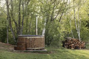 una bañera de madera junto a un montón de madera en Dragonfly Lake House εïз en Limbaži