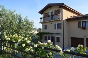 un bâtiment avec une clôture et des fleurs devant lui dans l'établissement B&B La Casa sul Fiume, à San Martino dallʼ Argine