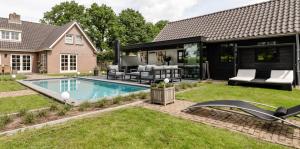 een achtertuin met een zwembad en een huis bij Brabants Genieten in Kaatsheuvel