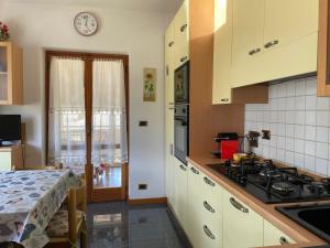 a kitchen with white cabinets and a stove top oven at Relax in Valle D'Aosta da B&G in Aosta