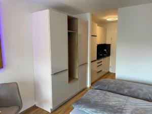 a living room with a white cabinet and a bed at Haus München in Bad Griesbach