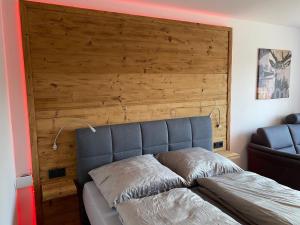a bed in a room with a wooden wall at Haus München in Bad Griesbach