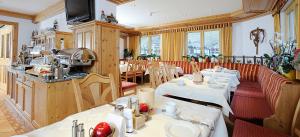 um restaurante com mesas e cadeiras num quarto em Hotel Kristall B&B em Ischgl