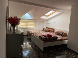 a bedroom with a bed and a vase of flowers at Lemberg Relax House in Lviv