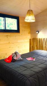 Habitación con cama grande en una cabaña de madera en La cabane des "Aventuriers" de Nature et Océan à côté de la plage, en Messanges