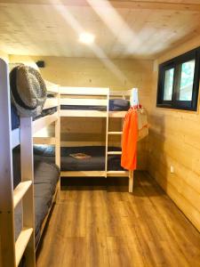 1 dormitorio con literas en una cabaña de madera en La cabane des "Aventuriers" de Nature et Océan à côté de la plage, en Messanges