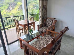 a living room with a table and chairs and a balcony at Two Rock Vista in Ella