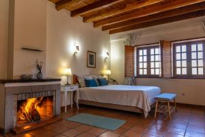 um quarto com uma cama e uma lareira em Quinta Do Crestelo Aparthotel em Seia