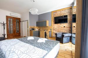 sypialnia z łóżkiem i ścianą z cegły w obiekcie Szymborska Apartamenty Mostowa 18-2 w Toruniu