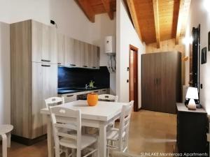 布呂松的住宿－Sunlake Estoul borgo，厨房以及带白色桌椅的用餐室。