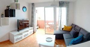 聖奧古斯丁的住宿－EL MORRO SEA VIEW APARTMENT，客厅配有蓝色的沙发和电视
