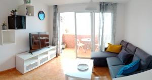 a living room with a blue couch and a tv at EL MORRO SEA VIEW APARTMENT in San Agustin